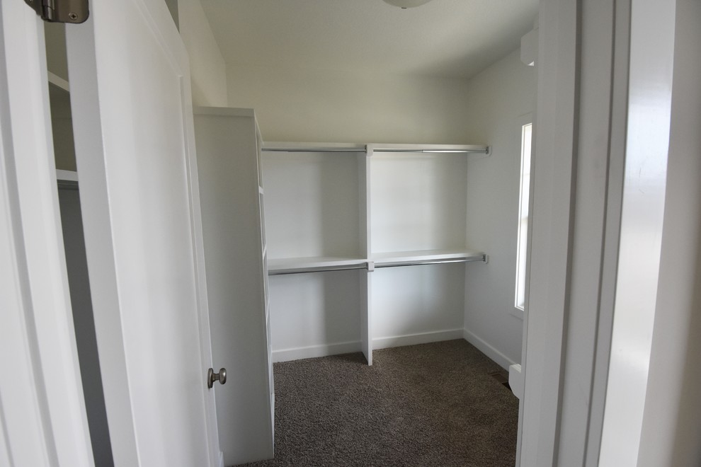 На фото: гардеробная комната среднего размера, унисекс в современном стиле с ковровым покрытием