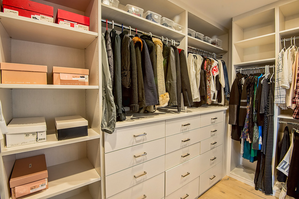 Foto de armario vestidor unisex actual de tamaño medio con armarios abiertos, puertas de armario beige y suelo de madera clara