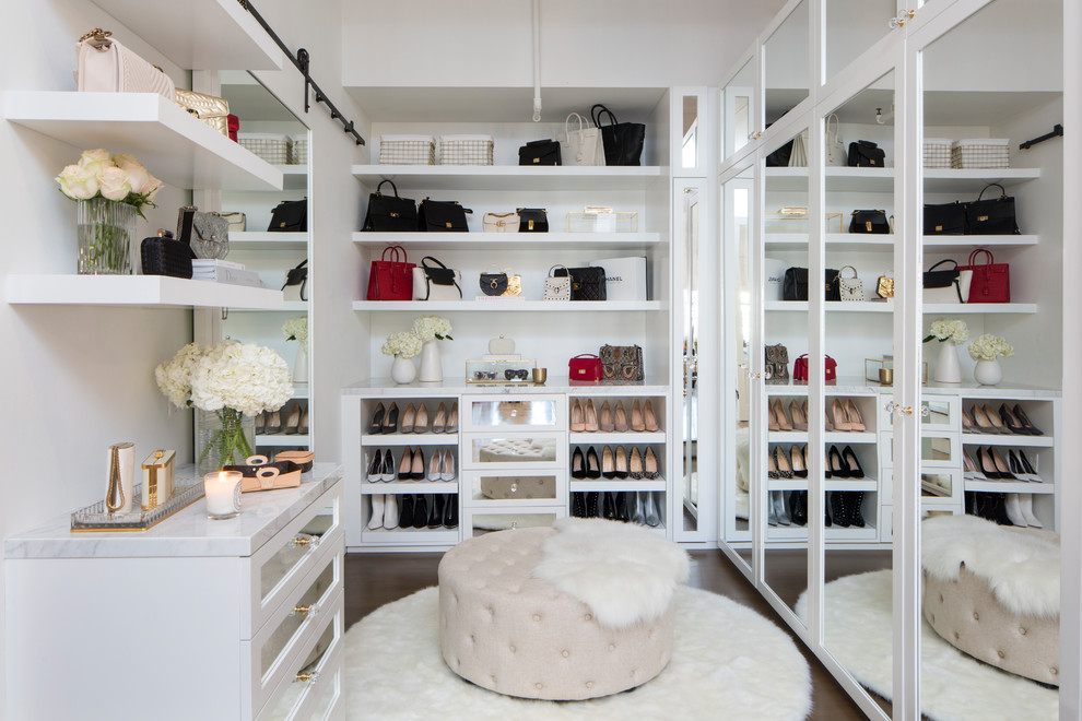 This is an example of a classic dressing room for women in Los Angeles with white cabinets and dark hardwood flooring.