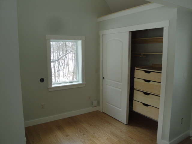 Inspiration for a large gender-neutral reach-in closet remodel in Portland Maine with light wood cabinets