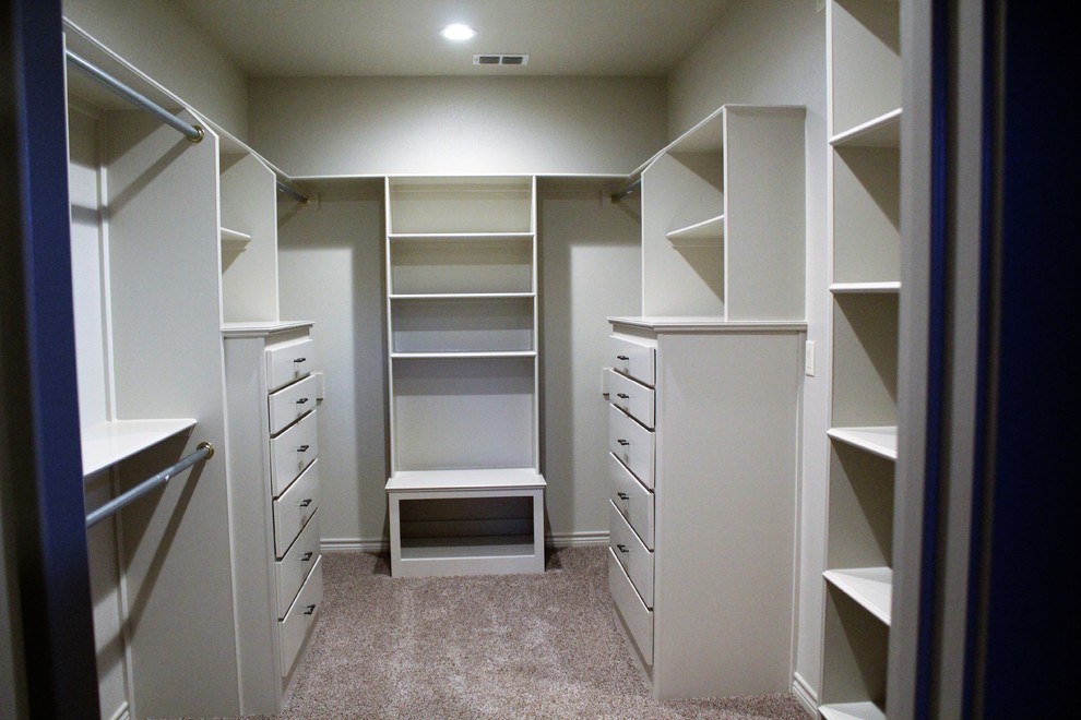 Inspiration for a large classic gender neutral walk-in wardrobe in Dallas with flat-panel cabinets, beige cabinets, carpet and brown floors.
