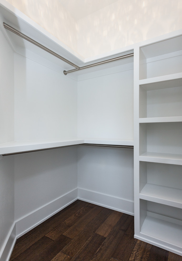 Ejemplo de armario vestidor unisex minimalista de tamaño medio con suelo de madera oscura