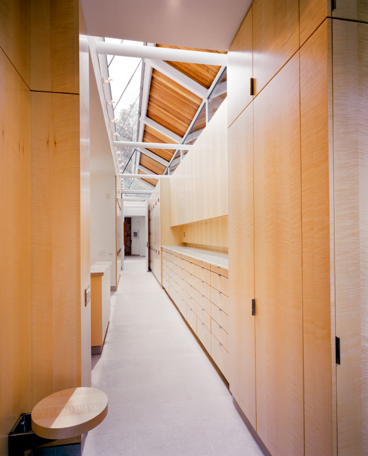 Foto di armadi e cabine armadio moderni con ante lisce, ante in legno chiaro e pavimento in pietra calcarea