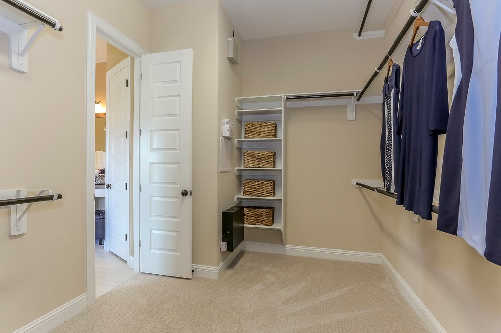 Foto på ett stort lantligt walk-in-closet för könsneutrala, med öppna hyllor, vita skåp, heltäckningsmatta och beiget golv