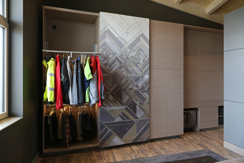 Idee per un armadio o armadio a muro per uomo design con ante lisce, ante in legno chiaro e pavimento in legno massello medio