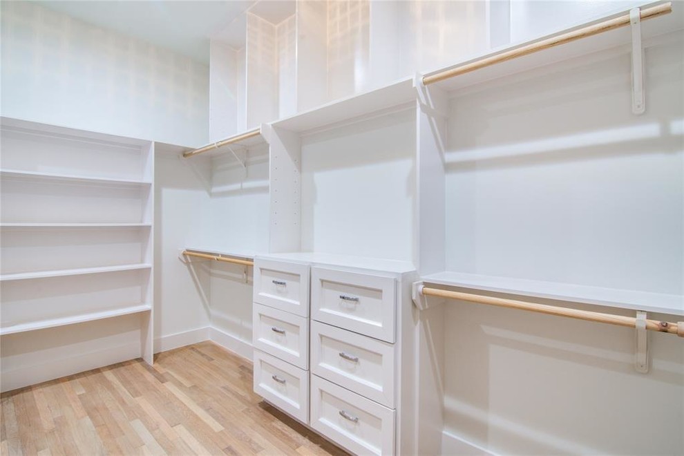 Foto de armario vestidor unisex contemporáneo grande con armarios estilo shaker, puertas de armario blancas, suelo de madera clara y suelo beige