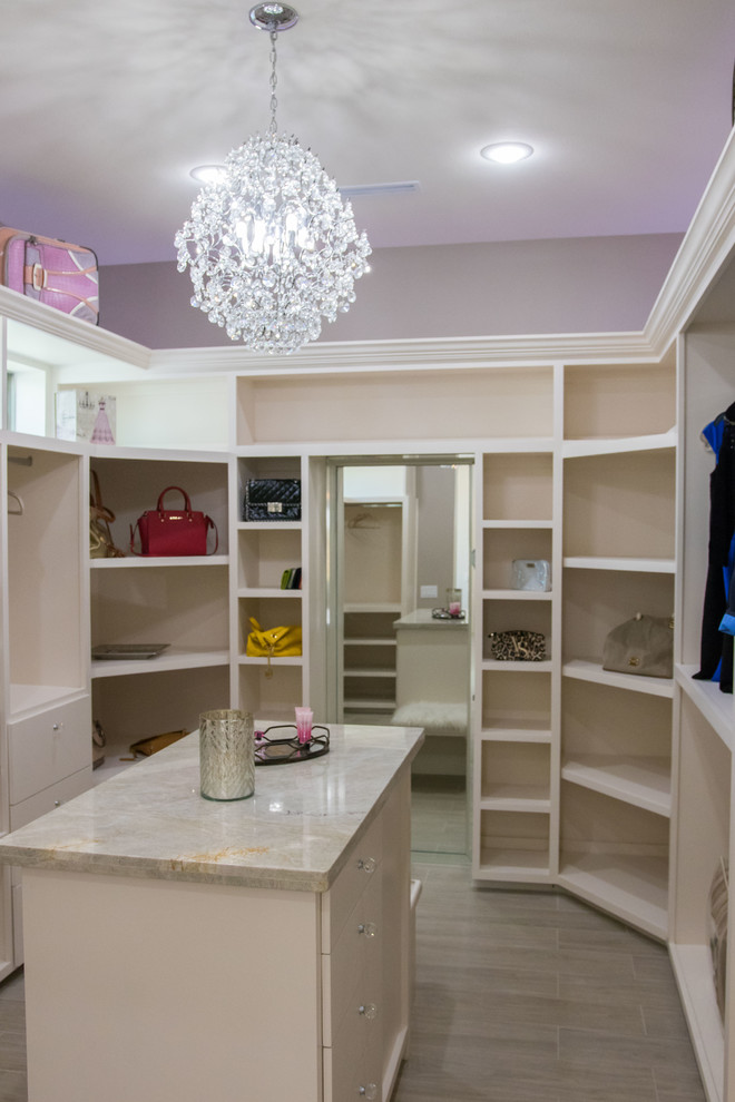 Exempel på ett mellanstort modernt walk-in-closet för kvinnor, med släta luckor, vita skåp, ljust trägolv och grått golv