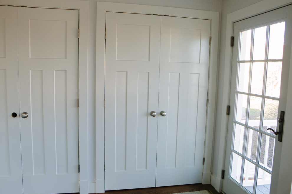 Foto di un armadio o armadio a muro unisex stile marino con ante con riquadro incassato, ante bianche e pavimento in legno massello medio