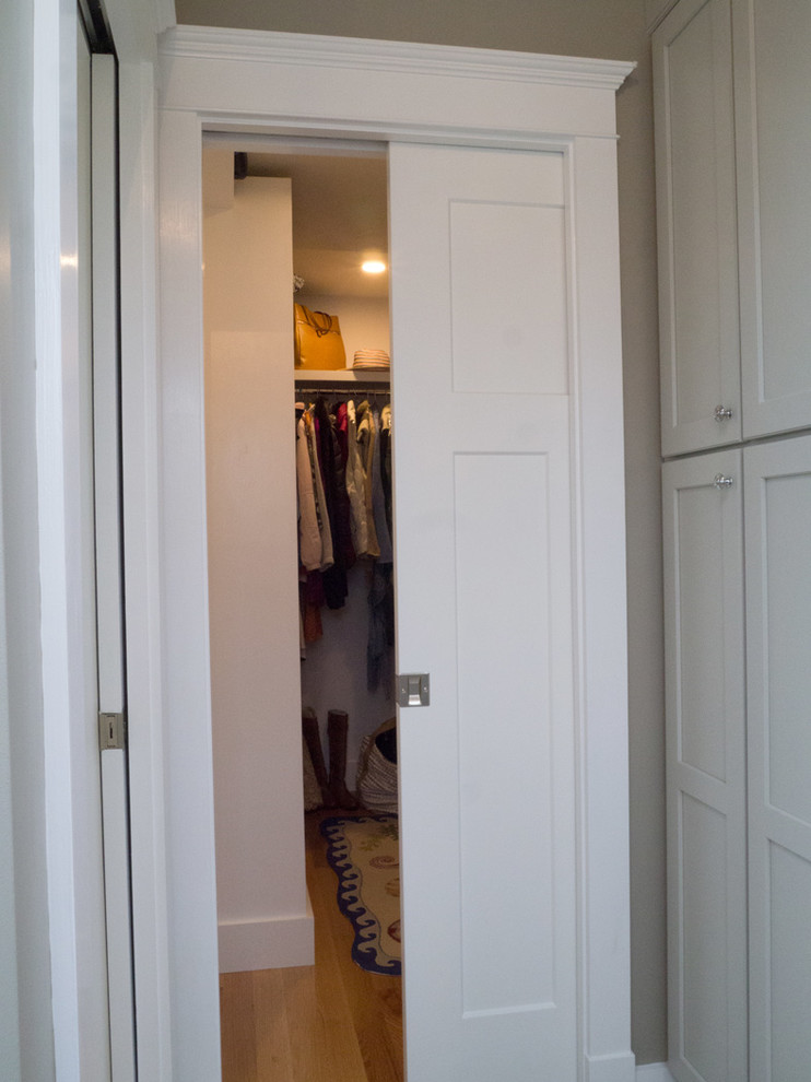 Maritim inredning av ett mellanstort walk-in-closet för kvinnor, med ljust trägolv