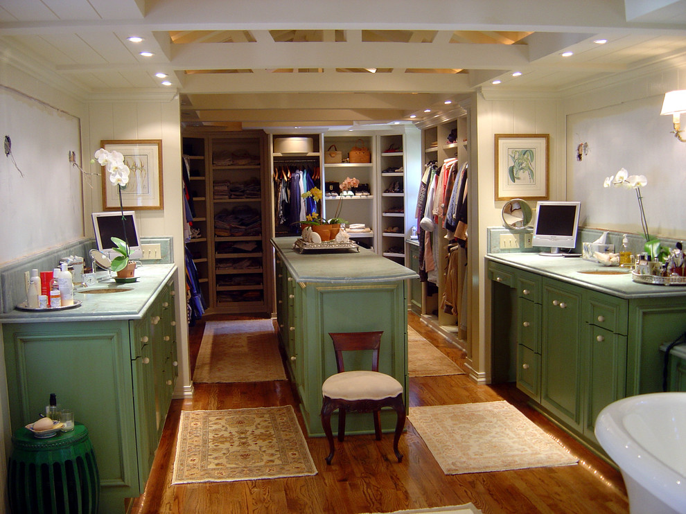 Modelo de armario vestidor unisex tradicional grande con armarios con paneles con relieve, puertas de armario con efecto envejecido y suelo de madera en tonos medios