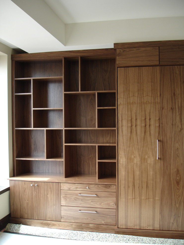 Aménagement d'un grand dressing room moderne en bois foncé neutre avec un placard à porte plane, moquette et un sol beige.