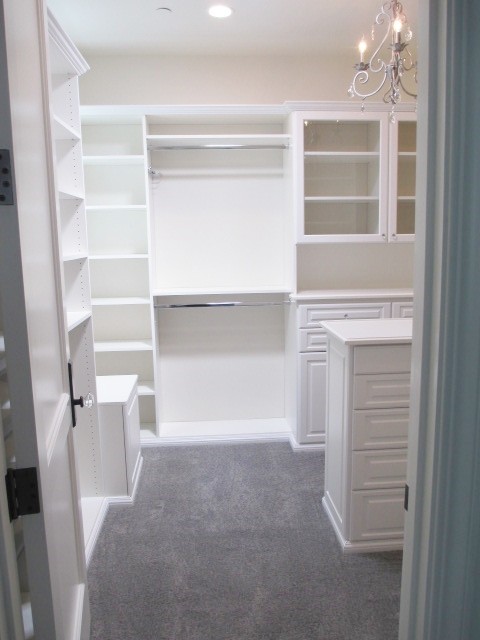 Diseño de armario vestidor unisex clásico grande con armarios con paneles con relieve, puertas de armario blancas, moqueta y suelo gris