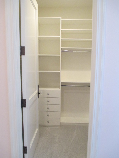 Modelo de armario vestidor unisex clásico grande con puertas de armario blancas, moqueta, armarios con paneles con relieve y suelo gris
