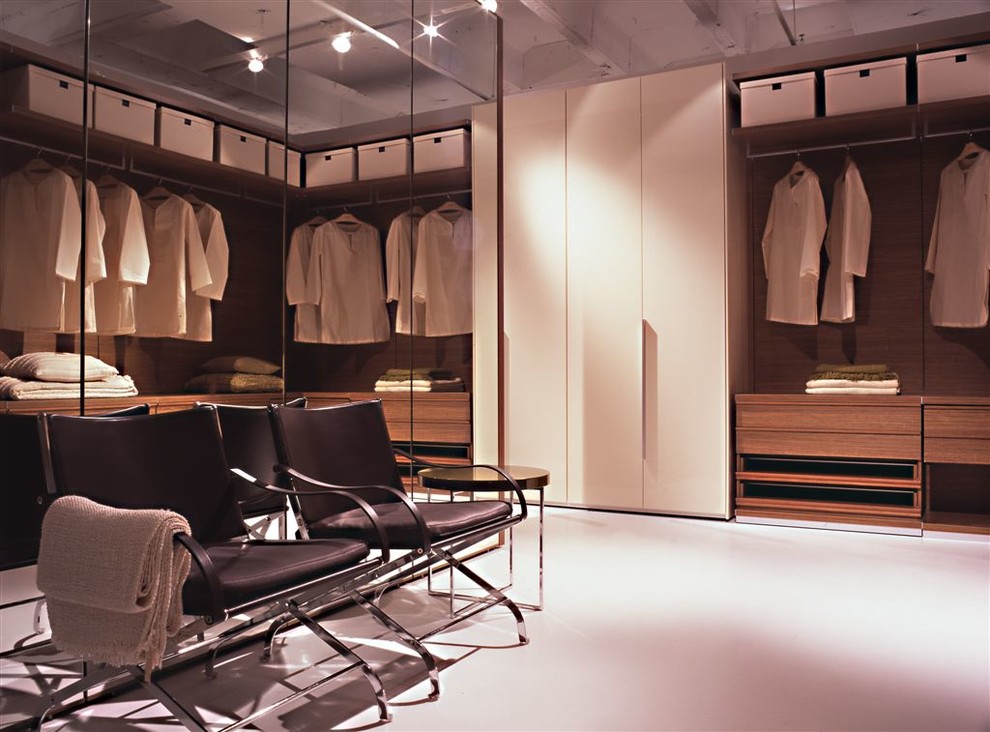 Cette image montre un grand dressing minimaliste en bois clair neutre avec un placard à porte plane et sol en béton ciré.