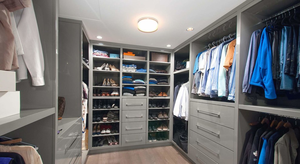 Imagen de armario vestidor unisex contemporáneo de tamaño medio con armarios con paneles lisos, puertas de armario grises y suelo de baldosas de porcelana