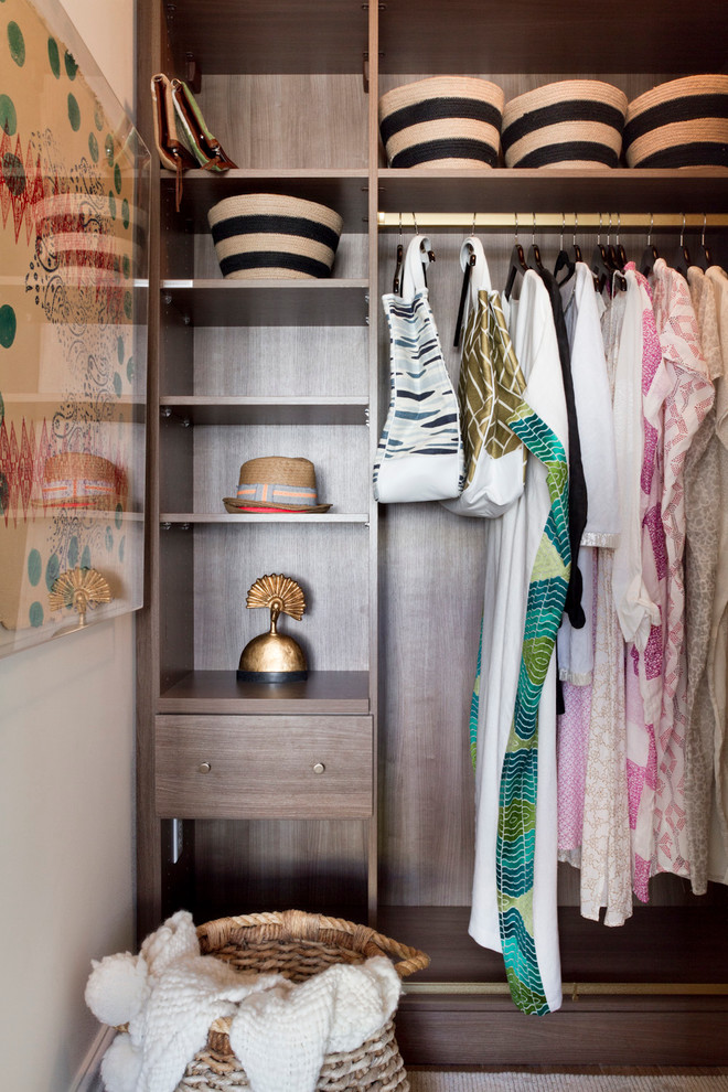 Example of a trendy women's closet design in New York with open cabinets and dark wood cabinets