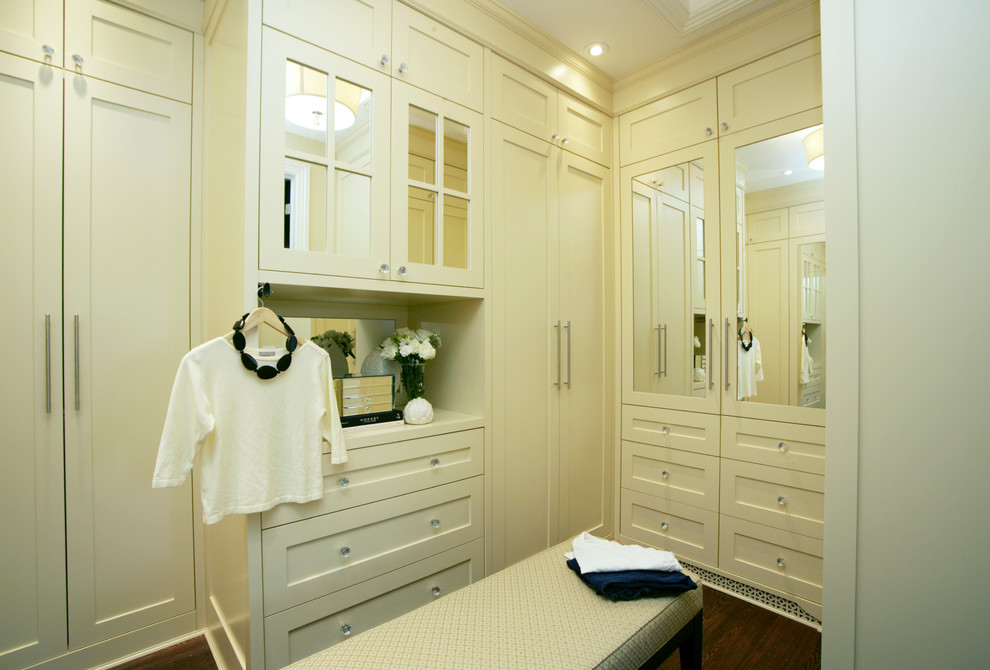 На фото: гардеробная комната среднего размера в классическом стиле с белыми фасадами, фасадами в стиле шейкер и темным паркетным полом для женщин с