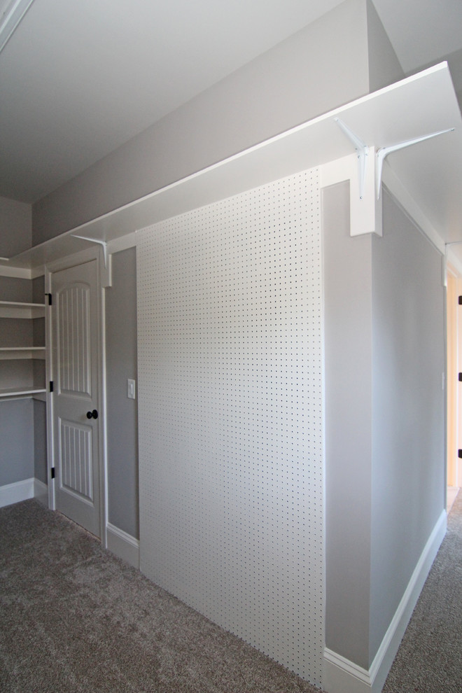 Example of a huge classic gender-neutral carpeted walk-in closet design in Raleigh with open cabinets and white cabinets
