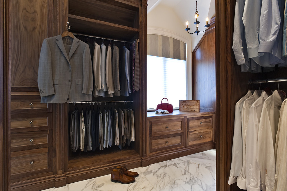 Inspiration for a large timeless men's marble floor walk-in closet remodel in Toronto with dark wood cabinets and recessed-panel cabinets