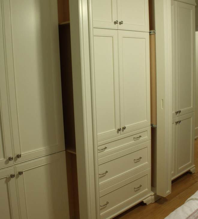 Immagine di un piccolo armadio o armadio a muro unisex tradizionale con ante con riquadro incassato, ante bianche e pavimento in legno massello medio