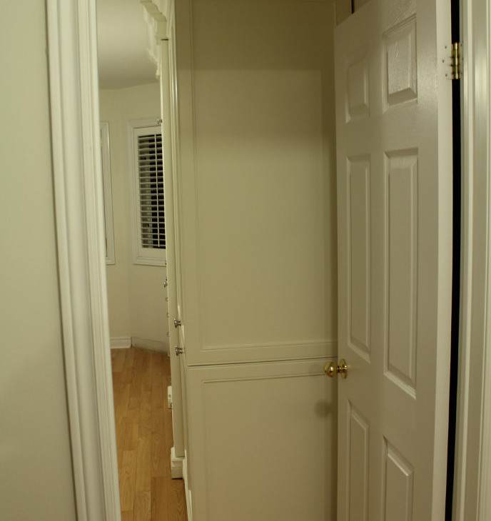 Esempio di un piccolo armadio o armadio a muro unisex chic con ante con riquadro incassato, ante bianche e pavimento in legno massello medio