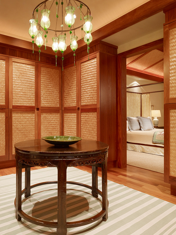 Ankleidezimmer mit Ankleidebereich, flächenbündigen Schrankfronten und hellbraunen Holzschränken in Hawaii
