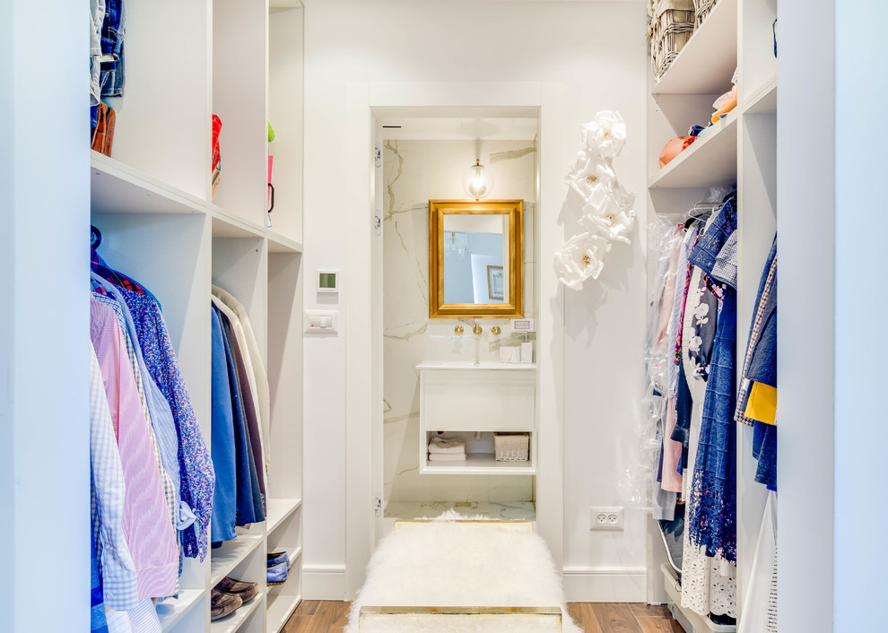 Foto de armario vestidor unisex contemporáneo con armarios abiertos, puertas de armario blancas y suelo marrón