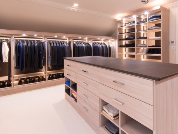 Modelo de armario vestidor de hombre moderno grande con armarios abiertos, puertas de armario de madera clara y moqueta