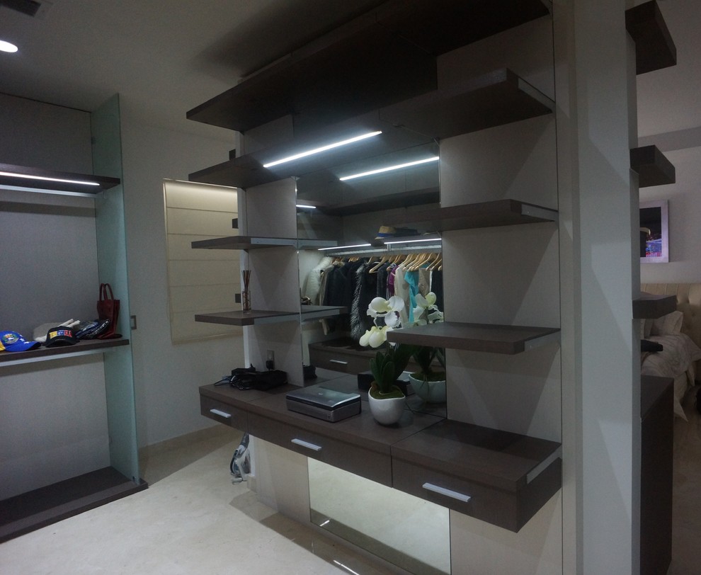 Inspiration for a large modern gender neutral walk-in wardrobe in Miami with flat-panel cabinets, dark wood cabinets and porcelain flooring.