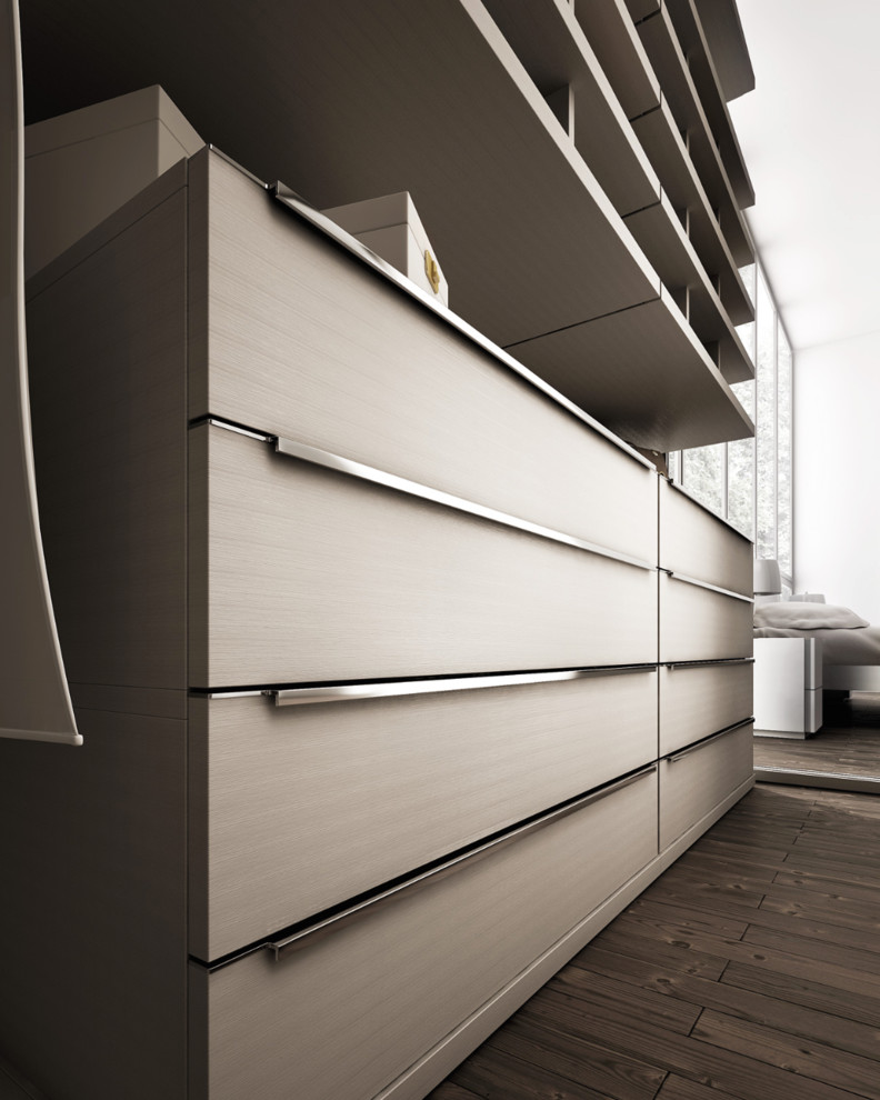 Modelo de armario vestidor unisex moderno grande con armarios con paneles lisos, puertas de armario beige y suelo de madera oscura