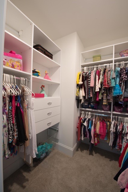 Ejemplo de armario vestidor unisex actual de tamaño medio con armarios con paneles lisos, puertas de armario blancas y moqueta