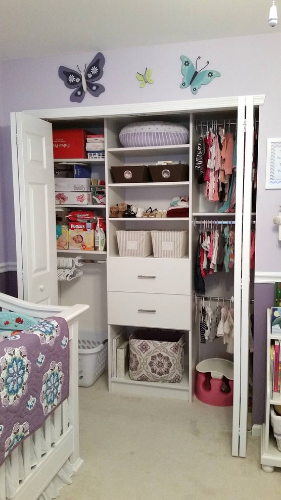This is an example of a medium sized traditional standard wardrobe for women in New York with flat-panel cabinets, white cabinets and carpet.