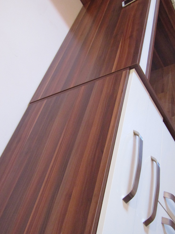 Esempio di un grande armadio o armadio a muro unisex minimalista con ante lisce, ante beige, pavimento in laminato e pavimento marrone