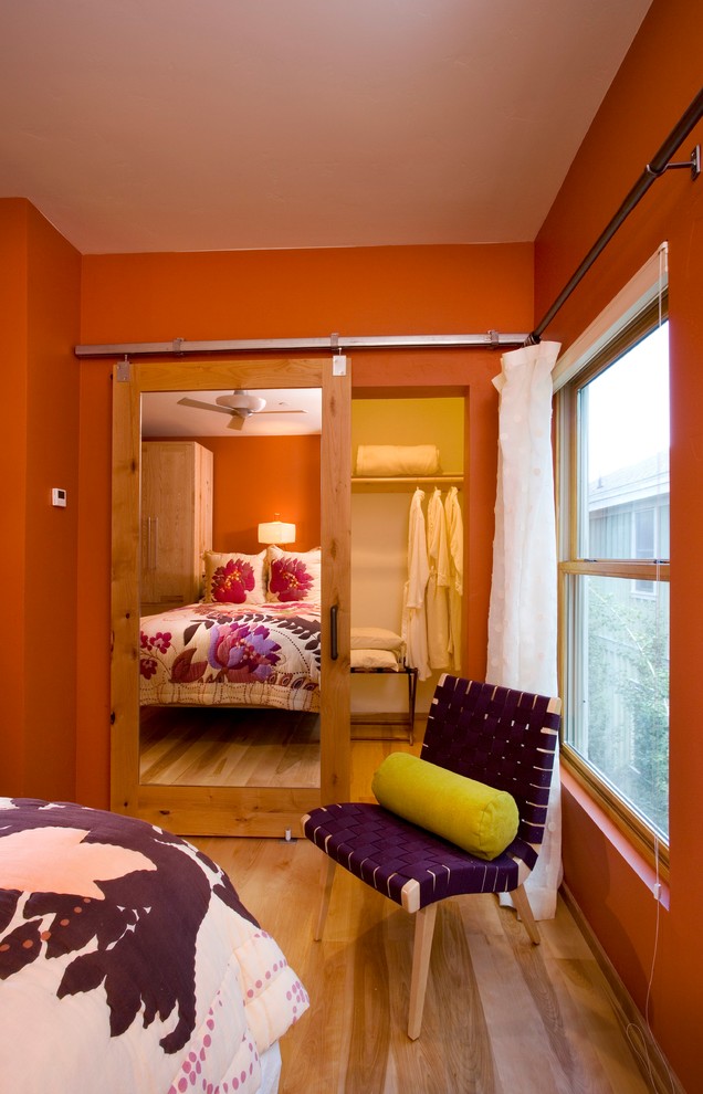 Ejemplo de armario y vestidor urbano de tamaño medio con suelo de madera en tonos medios y suelo marrón