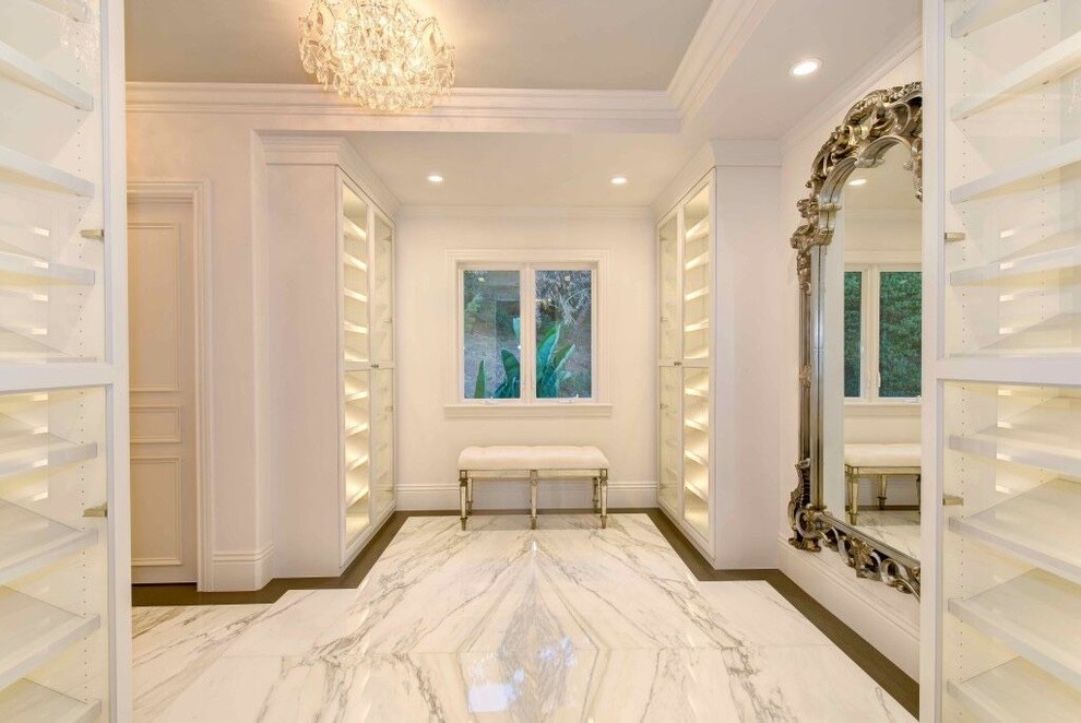 На фото: огромная гардеробная комната унисекс в современном стиле с открытыми фасадами, белыми фасадами и мраморным полом