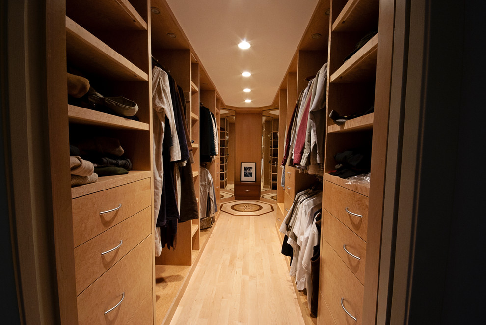Ejemplo de armario vestidor unisex contemporáneo grande con armarios con paneles lisos, puertas de armario de madera clara y suelo de madera clara