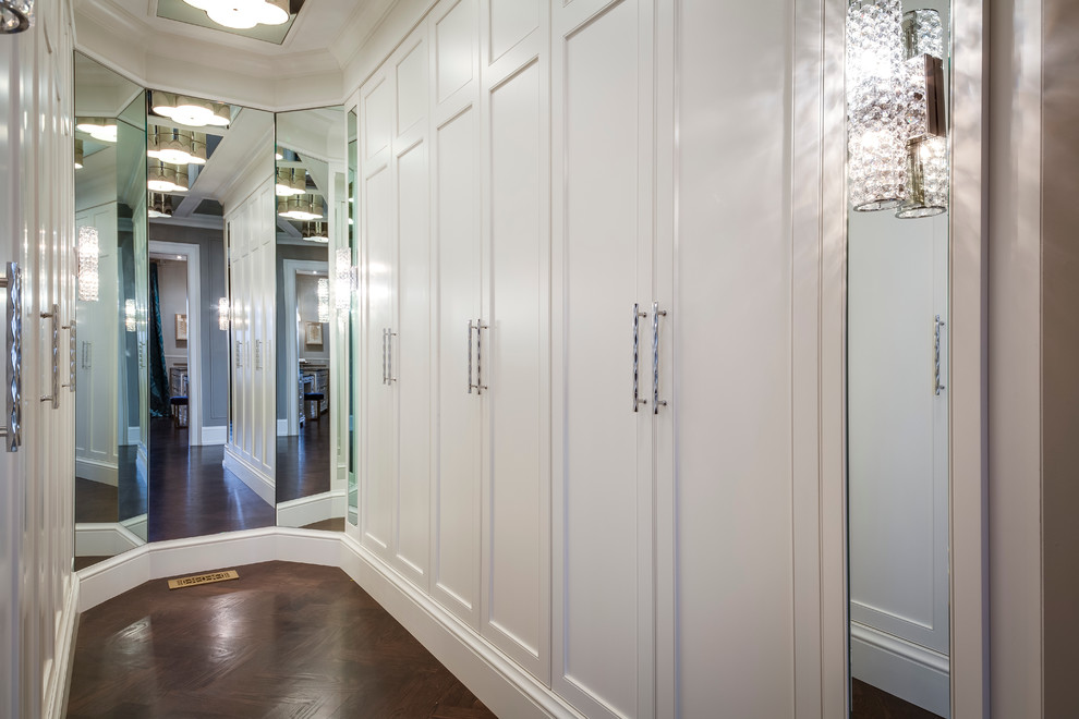 Ejemplo de vestidor unisex minimalista de tamaño medio con armarios con rebordes decorativos, puertas de armario blancas y suelo de madera en tonos medios