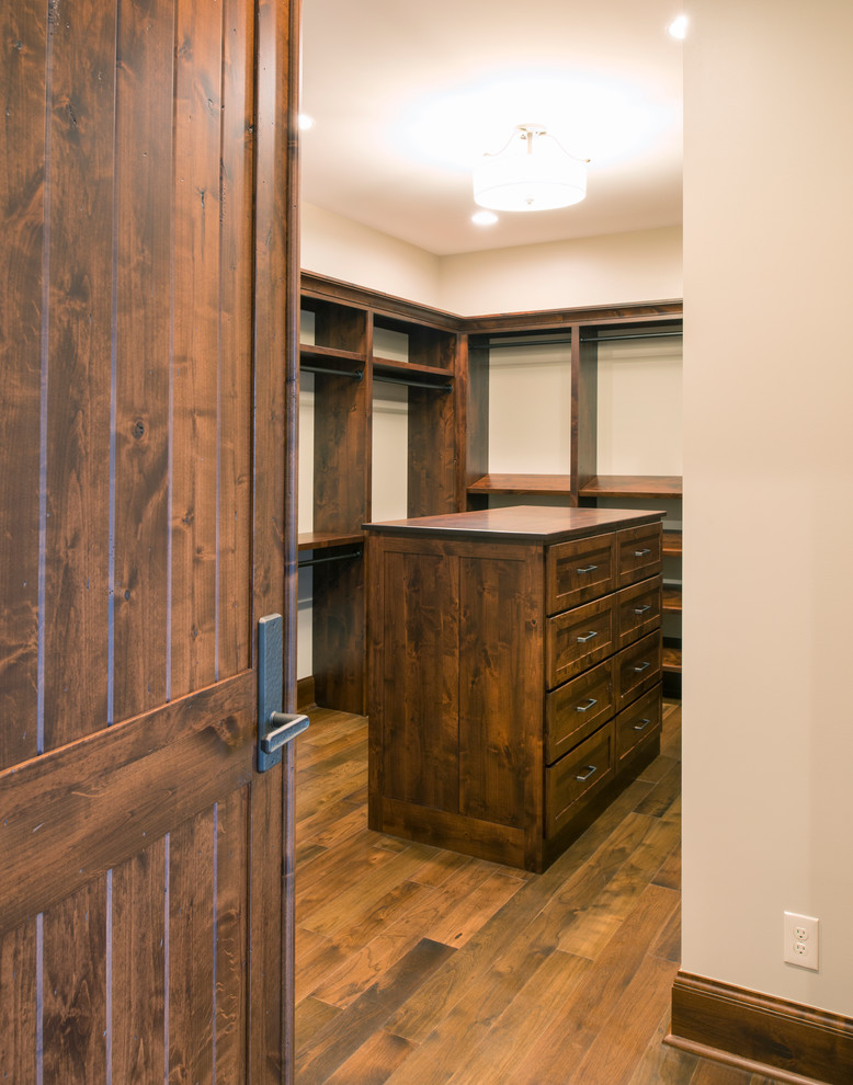 Foto de armario vestidor unisex rústico grande con armarios abiertos, puertas de armario de madera en tonos medios, suelo de madera en tonos medios y suelo marrón