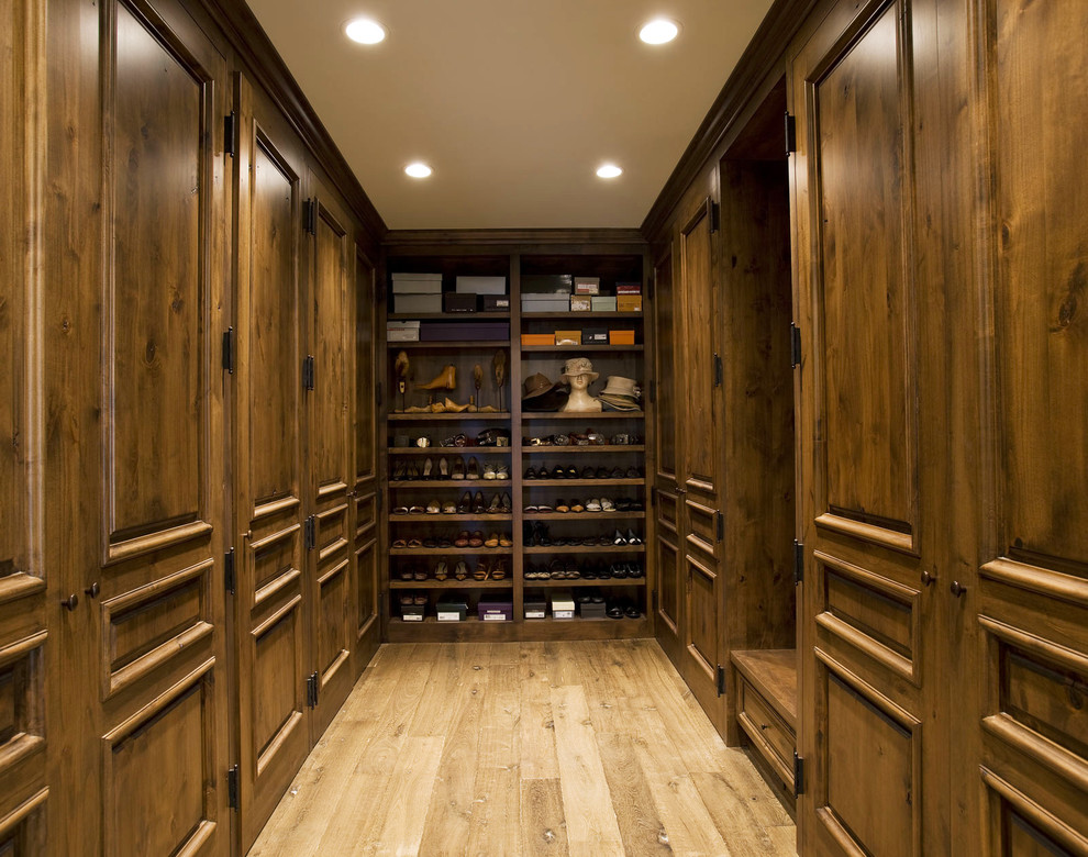 Inspiration för ett stort vintage walk-in-closet för män, med luckor med upphöjd panel, skåp i mellenmörkt trä, ljust trägolv och brunt golv