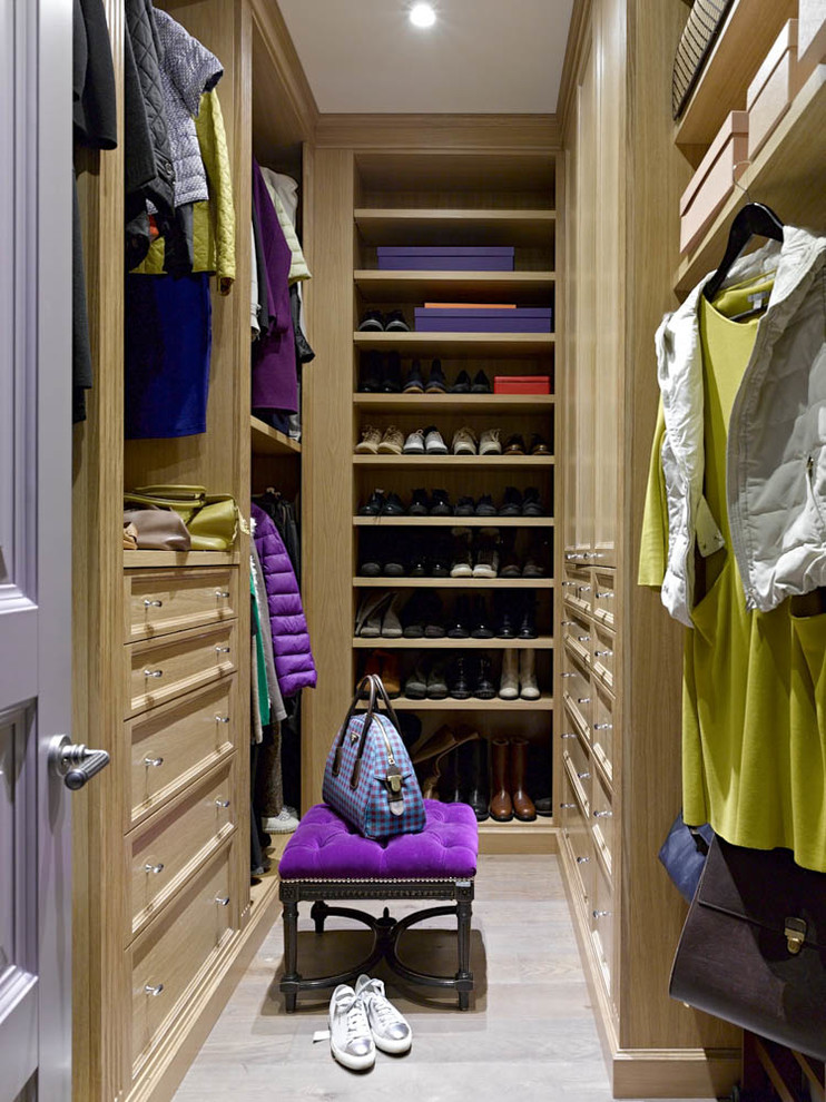 Diseño de armario vestidor unisex tradicional renovado con armarios con paneles empotrados, puertas de armario de madera clara, suelo de madera clara y suelo gris