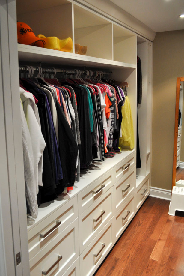 Imagen de armario vestidor unisex clásico renovado con puertas de armario blancas, suelo de madera en tonos medios y armarios con paneles empotrados