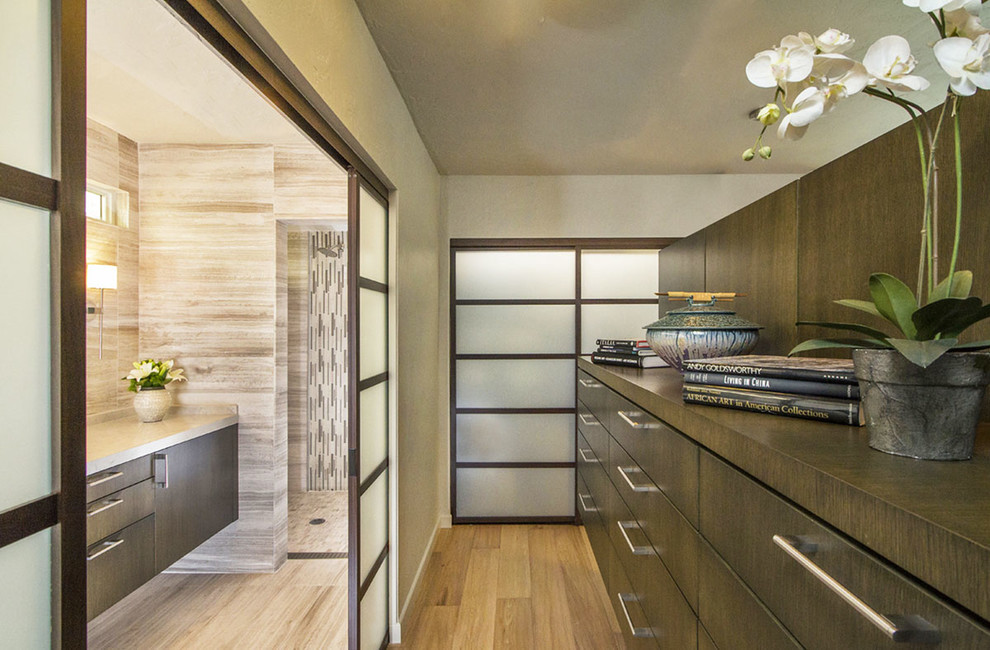Inspiration for a mid-sized contemporary gender-neutral light wood floor dressing room remodel in San Diego with medium tone wood cabinets