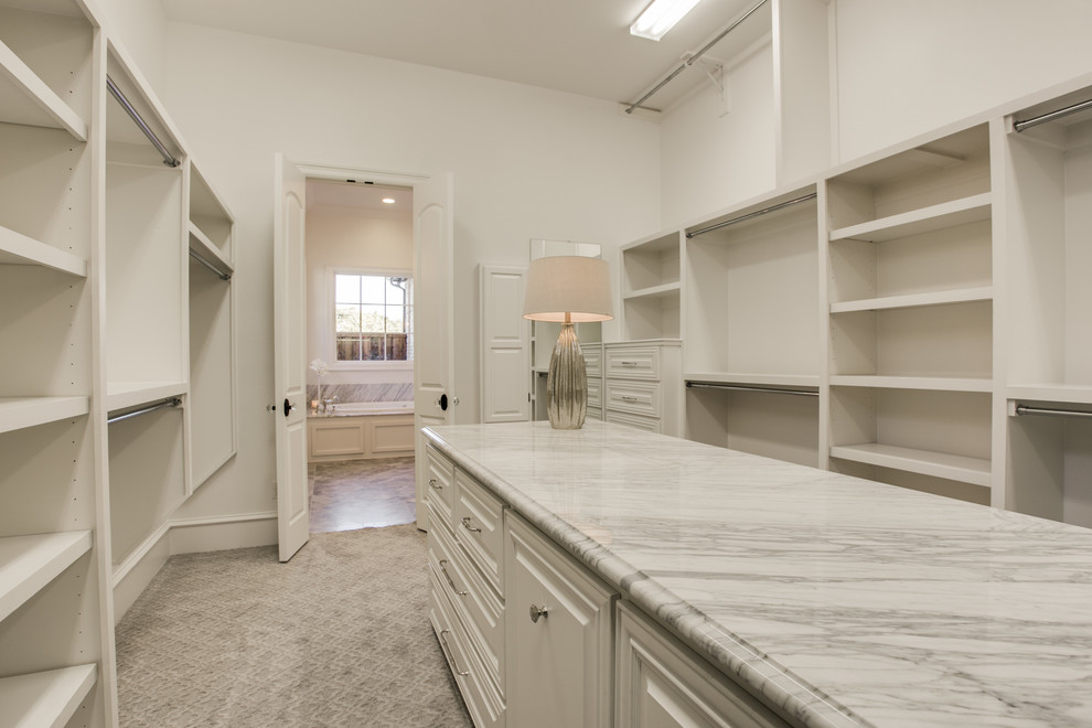 Inspiration for a large classic gender neutral walk-in wardrobe in Dallas with raised-panel cabinets, white cabinets and carpet.