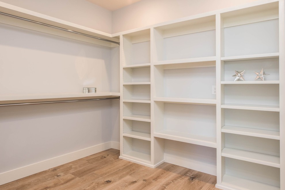 Inspiration for a large transitional gender-neutral light wood floor walk-in closet remodel in Orange County with open cabinets and white cabinets