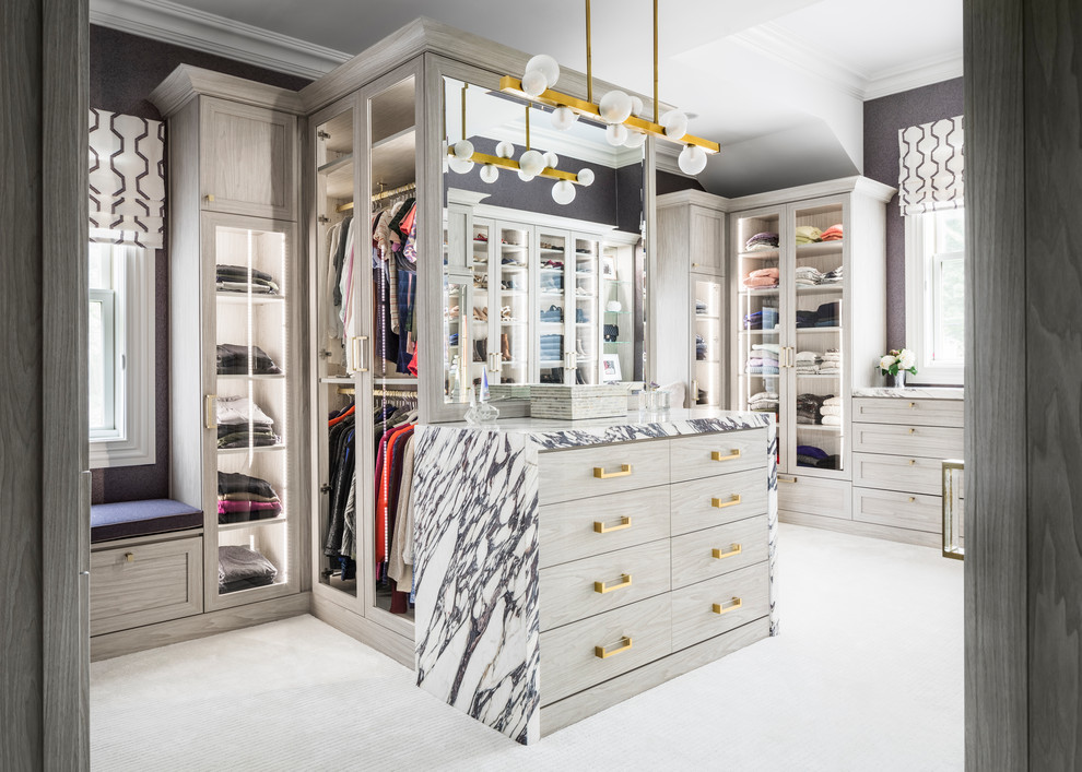 Inspiration for a contemporary walk-in wardrobe for women in New York with light wood cabinets, carpet, grey floors and shaker cabinets.