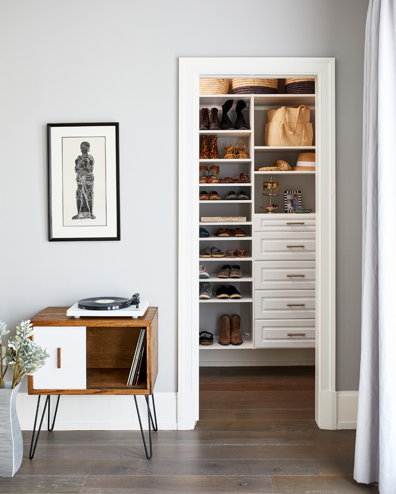 Diseño de armario clásico renovado con armarios con paneles con relieve, puertas de armario blancas, suelo de madera en tonos medios y suelo marrón