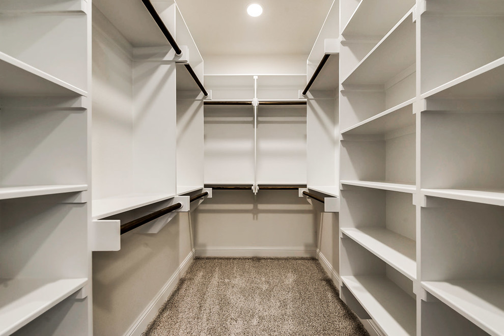 На фото: гардеробная комната среднего размера, унисекс в стиле неоклассика (современная классика) с ковровым покрытием с