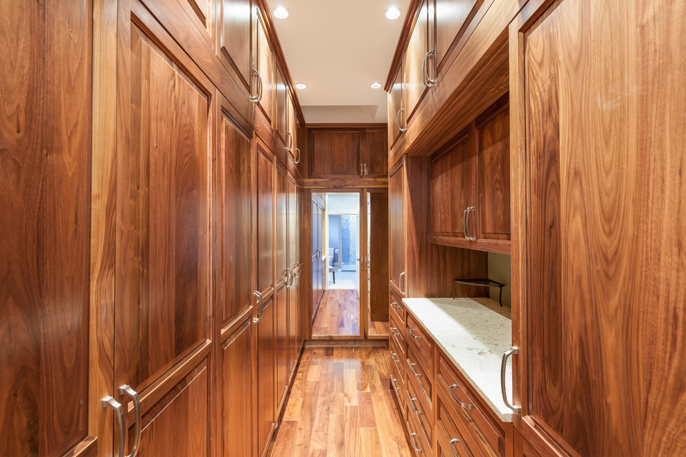 Foto di una grande cabina armadio unisex classica con ante con bugna sagomata, ante in legno scuro e pavimento in legno massello medio