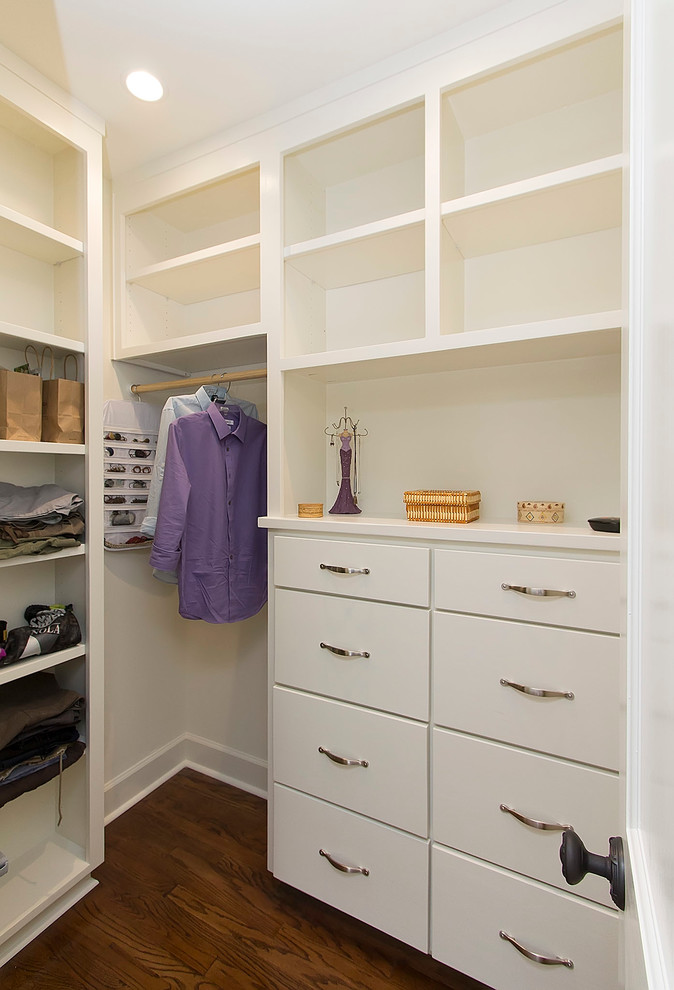 Diseño de armario vestidor unisex tradicional pequeño con armarios con paneles lisos, puertas de armario blancas y suelo de madera oscura