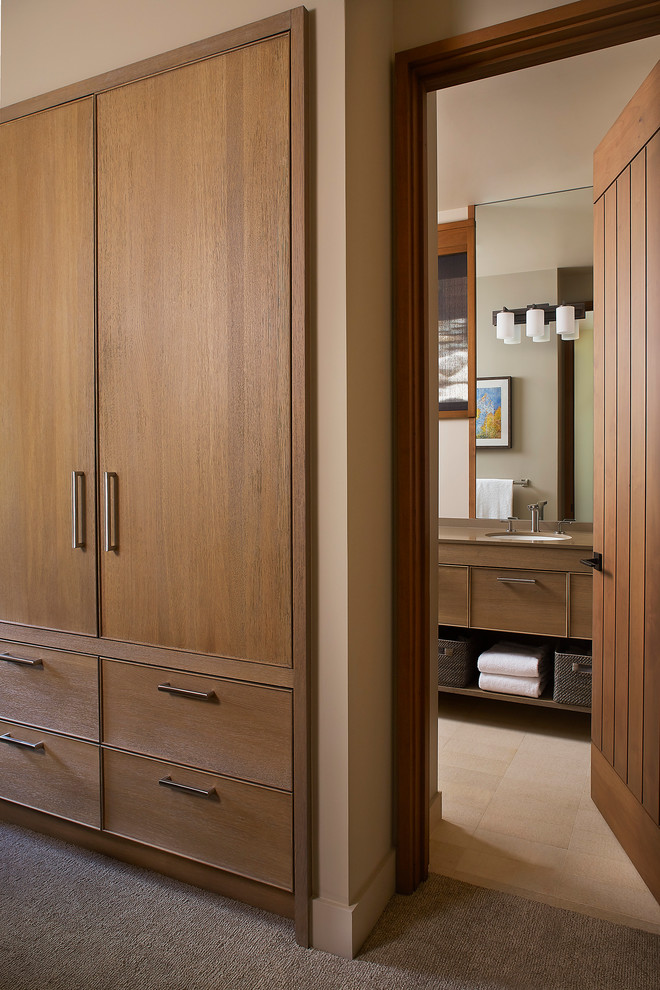 Foto de armario unisex tradicional renovado con armarios con rebordes decorativos, puertas de armario de madera clara, moqueta y suelo beige